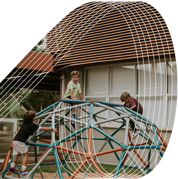 Three children climb on a geometric playground dome structure outside a building, with abstract white lines overlaid on the image.